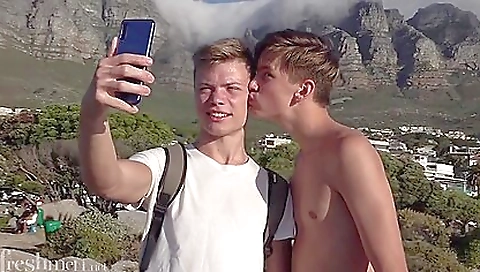 Two young guys rub each other's legs and spread their bodies